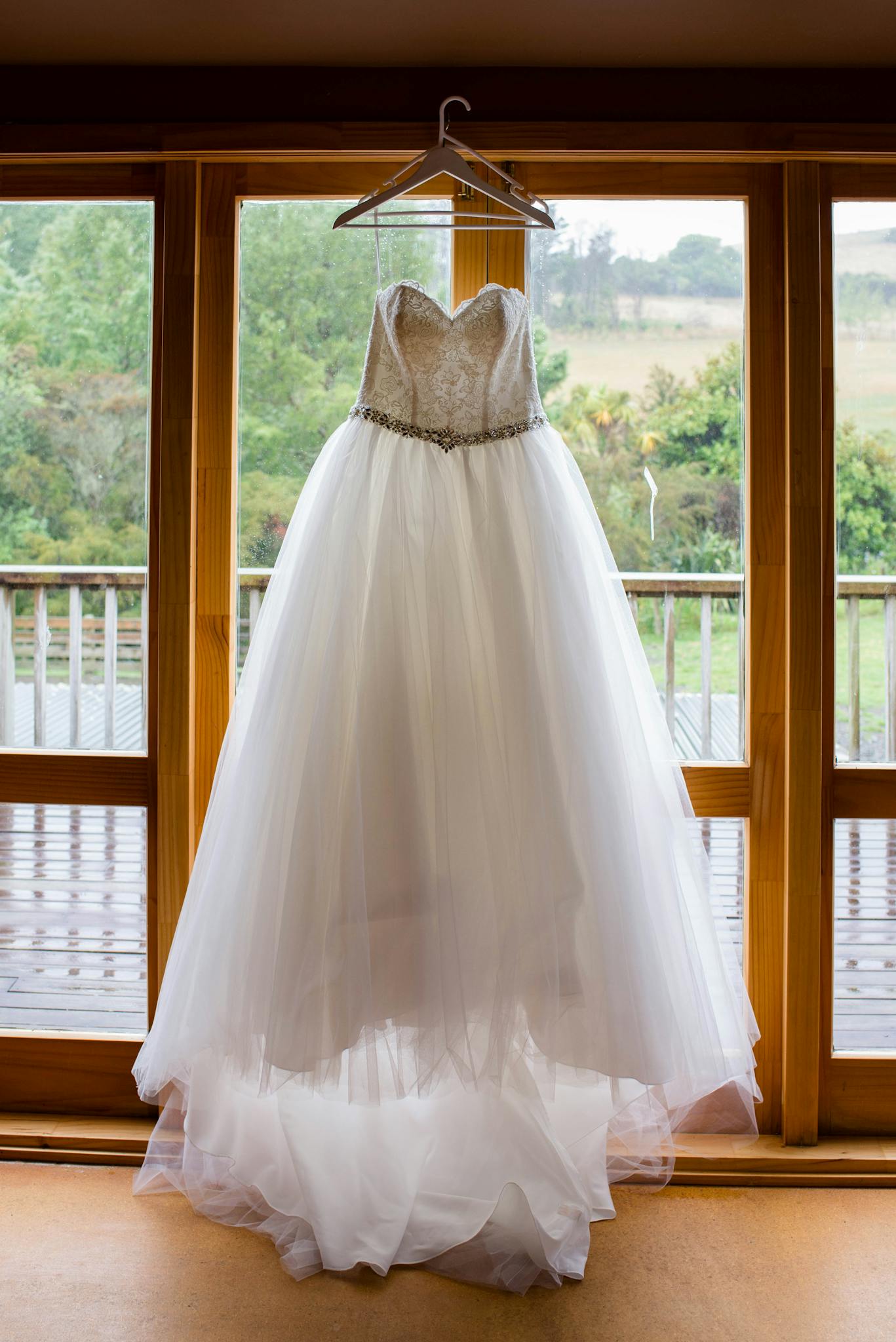 Elegant bridal dress hanging on window